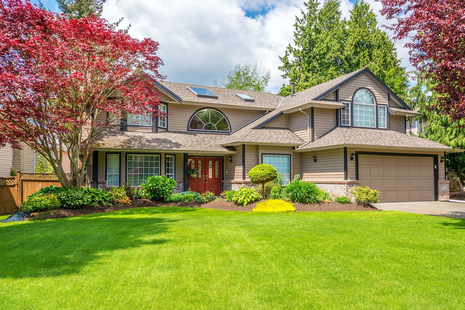 Luxury house with beautiful landscaping on a sunny day. Home exterior.