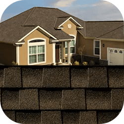 A suburban house with beige siding, white trim, and a dark gabled roof. The foreground features close-up textured black asphalt shingles.