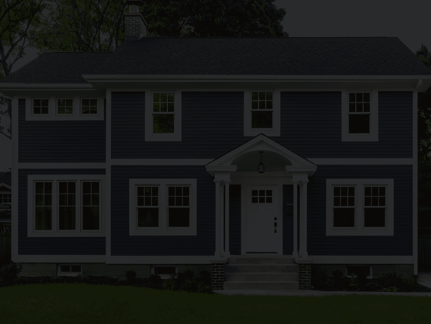 Two-story house with blue siding and white trim, three windows on each floor, a centered front door with steps, and a small porch. Peaceful evening setting.