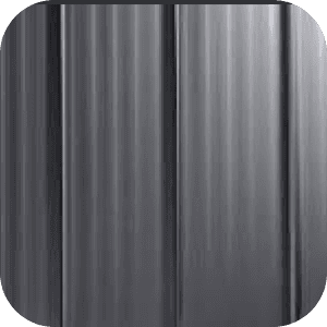 Close-up of a sleek, dark gray metallic surface with vertical ridges. The smooth texture and muted tones convey a modern, industrial feel.