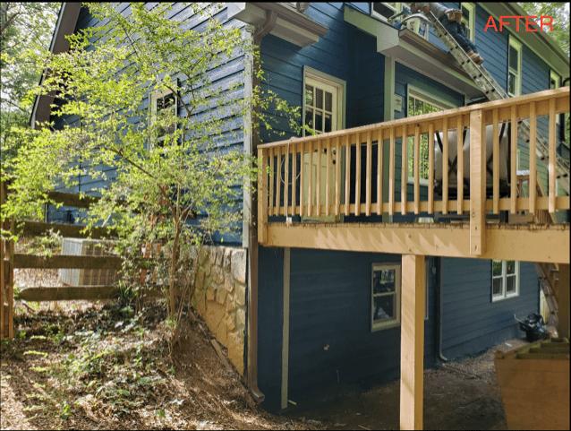 Two-story blue house with a new wooden deck, surrounded by lush greenery. The image has a fresh, serene vibe suggesting renovation completion.