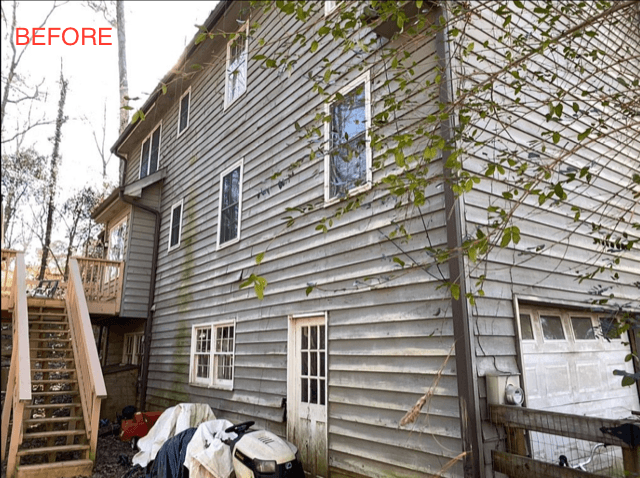 A weathered, three-story house exterior with gray wooden siding is shown before renovation. Overgrown foliage and outdoor clutter are visible beside the structure.